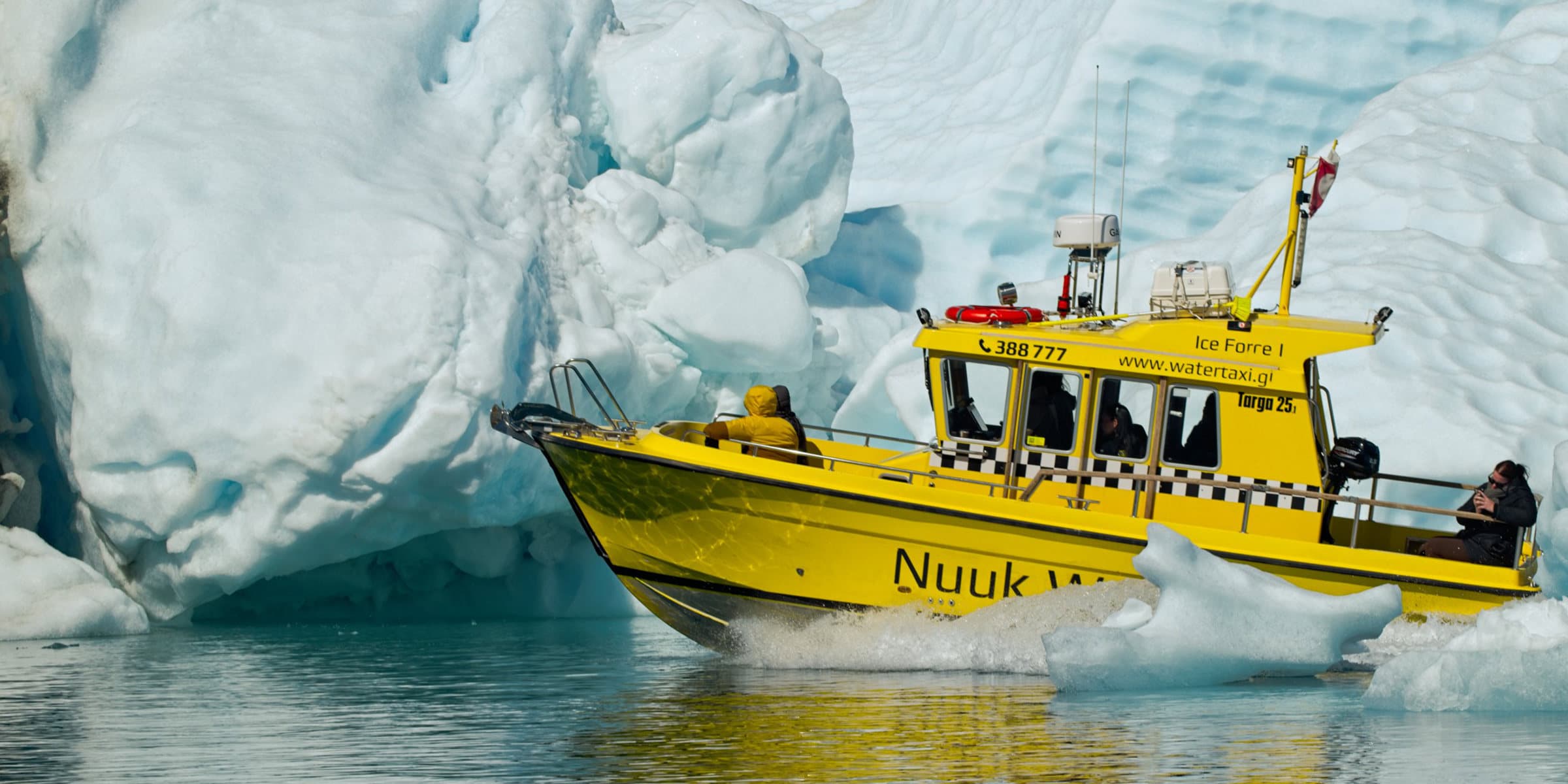 En Nuuk Water Taxi-båd sejler ved Grønlands is